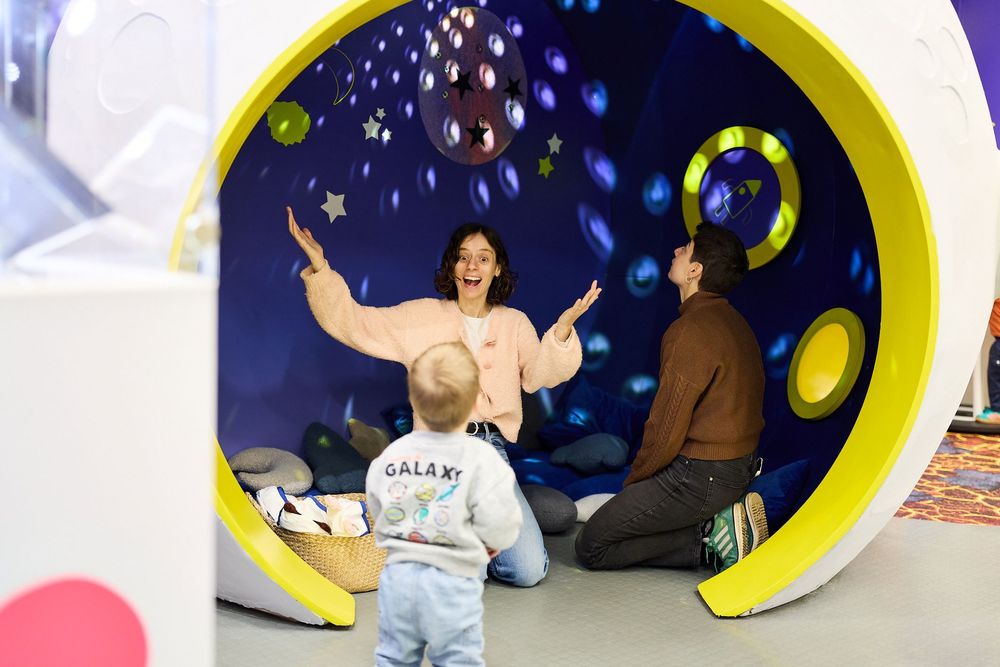 A parent and young child enjoy a sensory space in a library.