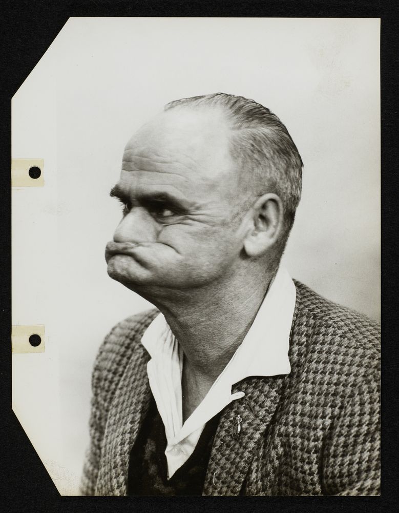 Sepia photo of man making an ugly, funny face