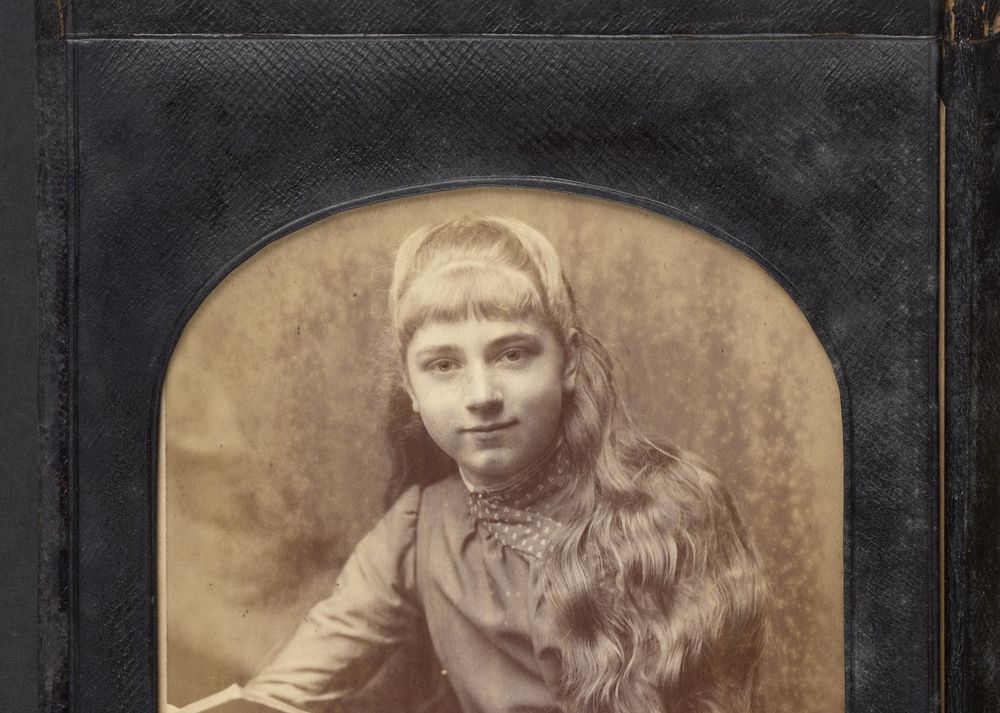 Sepia portrait of a Frances Wolseley as a girl, with long, wavy hair and fringe.
